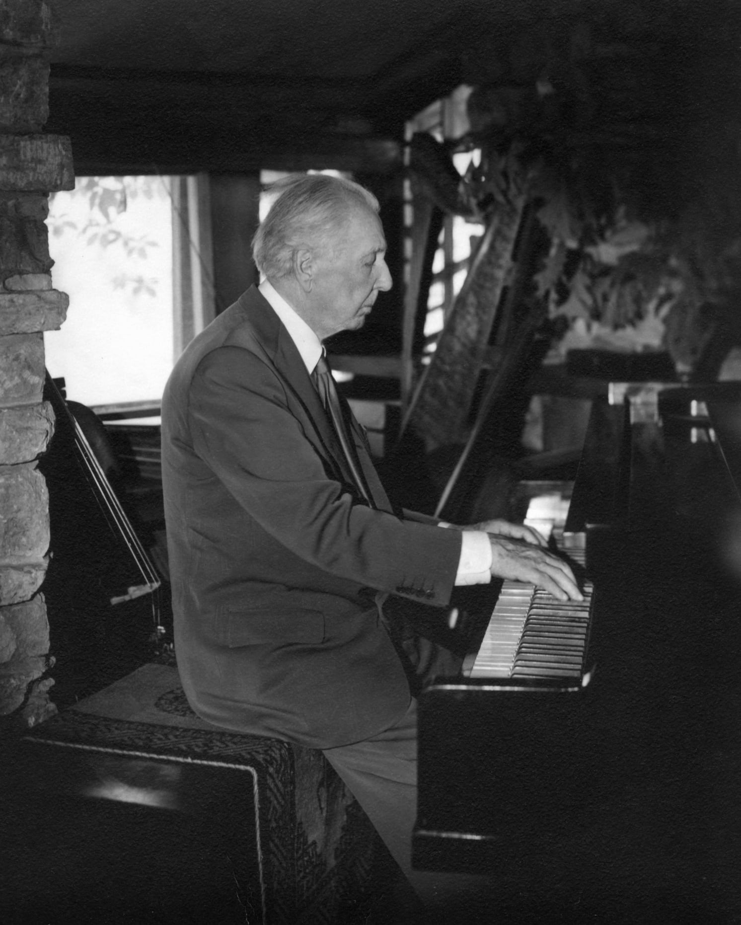 Frank Lloyd Wright playing the piano in 1955 at Taliesin during a photo