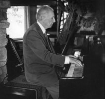 Frank Lloyd Wright playing the piano in 1955 at Taliesin during a photo shoot.