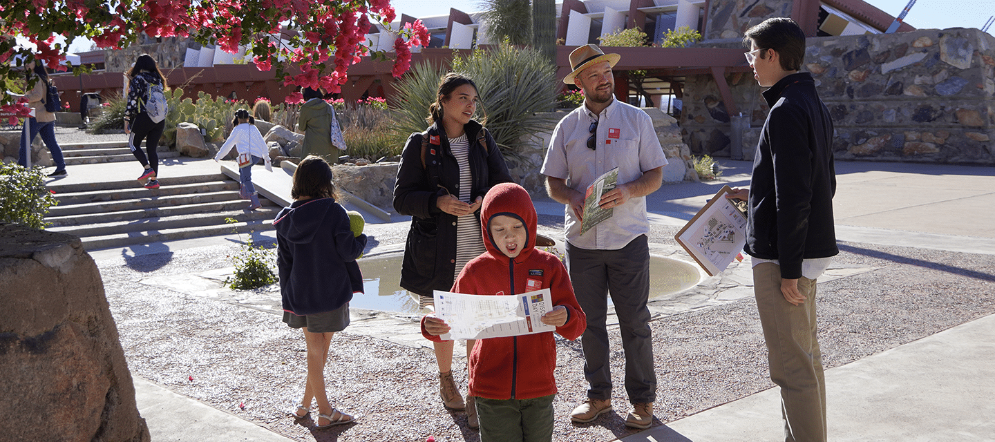 a family with young children talking with a guide prior to entering the property at Taliesin West