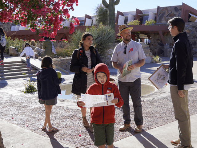 a family with young children talking with a guide prior to entering the property at Taliesin West