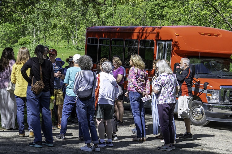 Guests on a tour of Taliesin with red tour bus