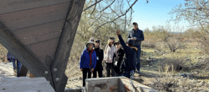 A group of visitors on the Shelters in the Desert Shelter Hike approaching a structure where one ofthe Apprentices lived at Taliesin West to learn about its history.