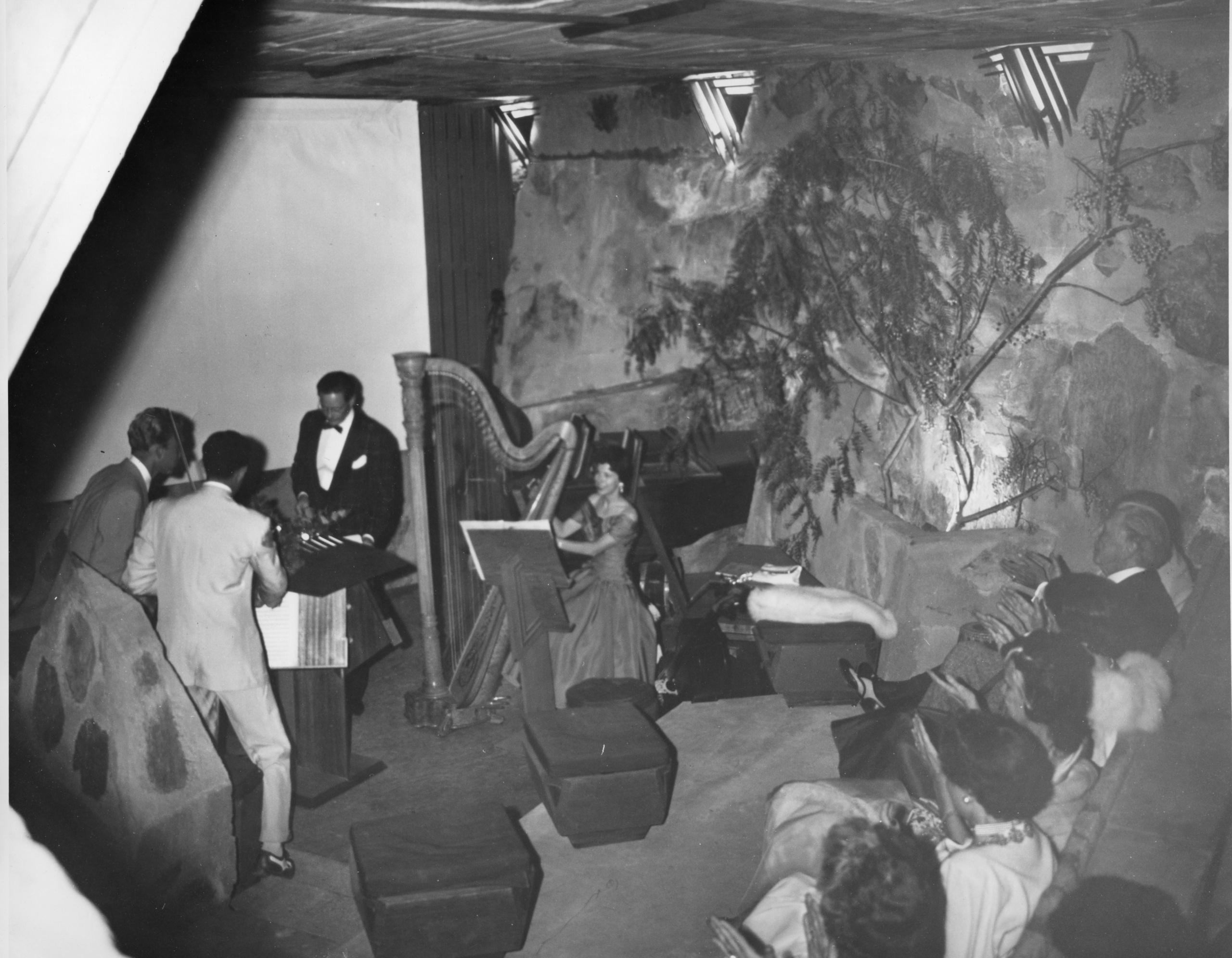 Olgivanna and Frank Lloyd Wright with the Taliesin Fellowship and guests enjoy a formal evening musical performance in the Cabaret Theater, 1950s. Photographer unknown. Frank Lloyd Wright Foundation Collections.